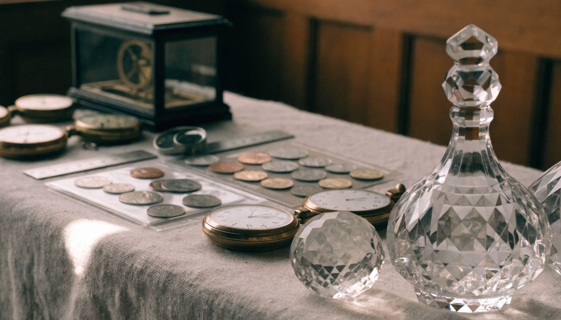 Representative image: crystal, pocket watches, a carriage clock and coins laid out on a linen tablecloth for cataloguing